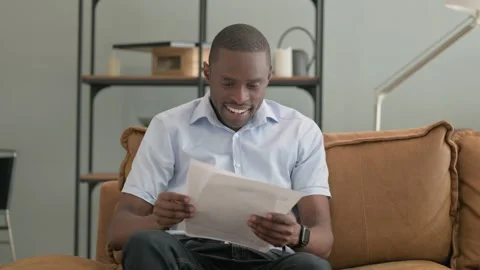 African Man Shocked by Loss while Reading Documents in Office Stock Footage 287915336