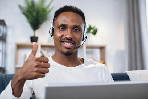 African man showing thumb up while working on laptop Stock Photos