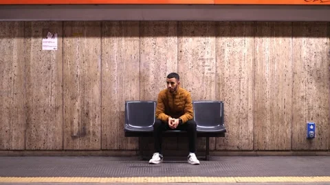 African man sitting in front of metro train and waiting for transport to stop Stock Footage 219868002