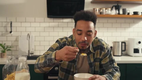 African man sitting at the kitchen table, eating a nutritious breakfast. Stock Footage 305048793