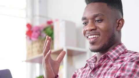 African man sitting on sofa and using smartphone to take video call Stock-Footage 167426727
