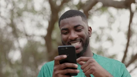 African Man with smartphone scrolling through newsfeed and online shops. Stock Footage 345506118