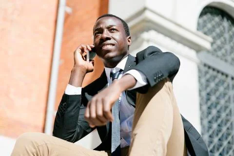African man smiling when he is using his mobile. Stock Photos