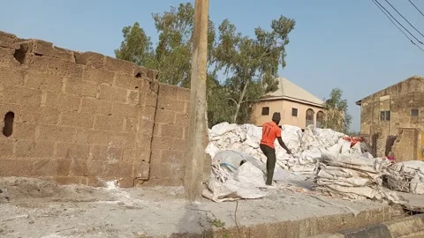 African Man Sorting Used Sacks By Roadside For Recycling Kano Nigeria Stock Footage 330561615