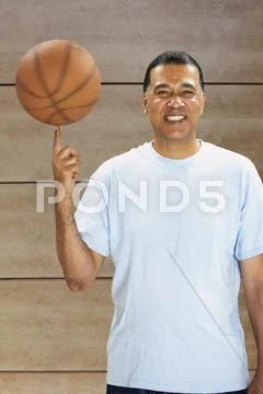 African man spinning basketball on finger Stock Photos