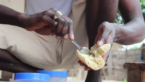 African man spreading butter on bread Stock Footage 232053182