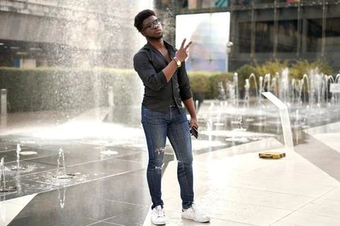 African man standing on a mall while gesturing victory with the hand Stock Photos