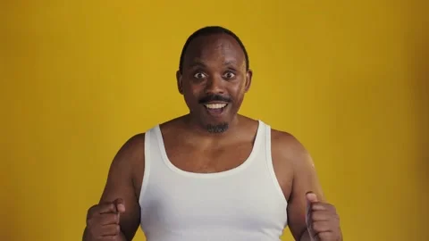 African man standing on a yellow background. Smiling for the camera Stock Footage 201292207