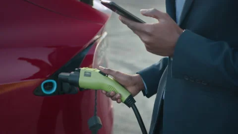 African man in suit solving urgent issues on smartphone while charging modern Stock Footage 155631436