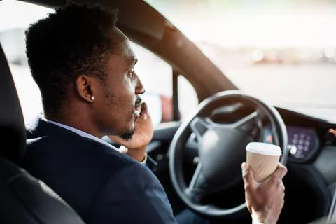African man talking on mobile while sitting in luxury car 스톡 사진