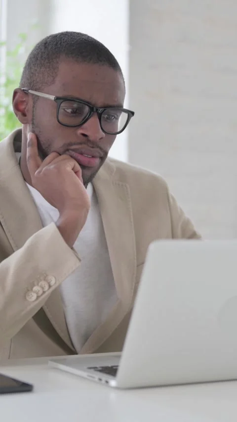 African Man Thinking while Working on Laptop in Office, Vertical Video Stock Footage 337350289