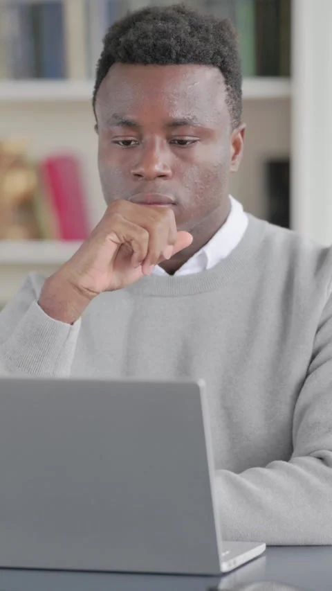 African Man Thinking while Working on Laptop in Library, Vertical Video Stock Footage 339575985
