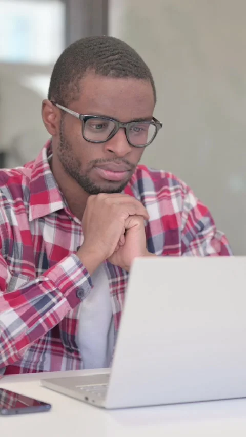 African Man Thinking while Working on Laptop, Vertical Video Stock Footage 340040028