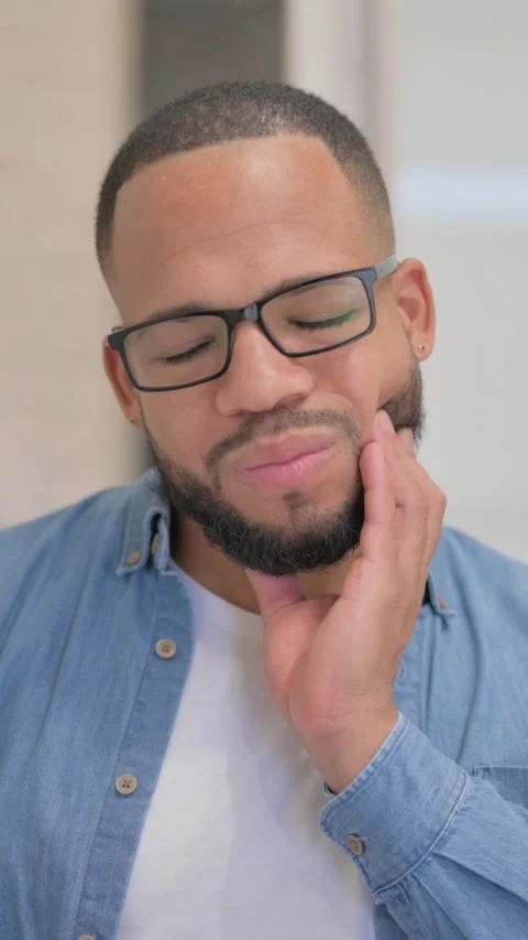 African Man with Toothache in Office, vertical video Stock Footage 325700706