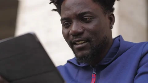 African man using digital tablet in the street: young black man using tablet Video stock 218603411