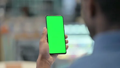 African Man Using Smartphone with Green Chroma Key Screen Stock Footage 146483232