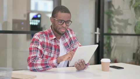 African Man using Tablet while Sitting in Office Stock Footage 164641445