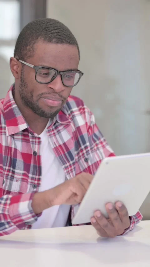 African Man using Tablet while Sitting in Office, Vertical Video Stock Footage 340040465