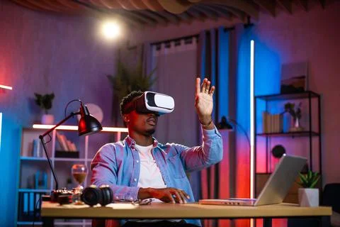 African man using VR glasses and laptop for remote work Fotos Stock