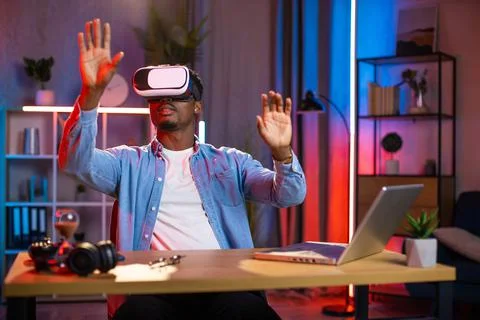 African man using VR glasses and laptop for remote work 스톡 사진