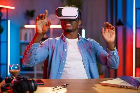 African man using VR glasses and laptop for remote work Stock-Fotos