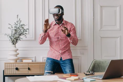 African man in VR headset interacting with digital interface, using innovative Foto stock