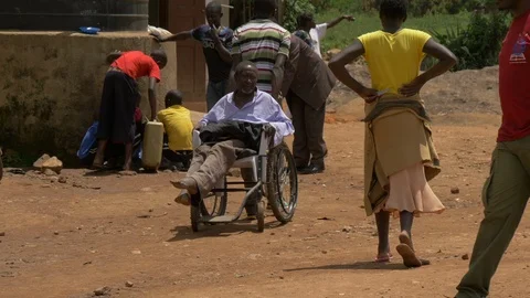 African man in wheelchair being pulled by a man Stock Footage 87066378