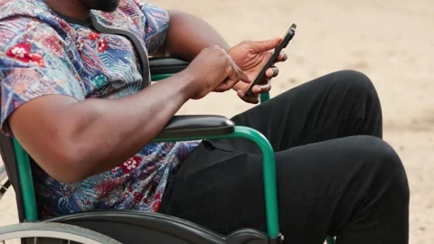 African Man in Wheelchair Using Laptop Outdoors: Remote Work &amp; Inclusion Stock Footage 346244892