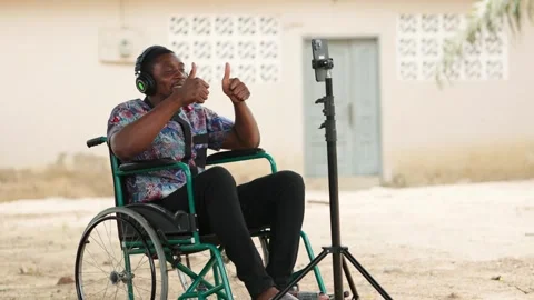 African Man in Wheelchair Using Smartphone for Video Call Stock Footage 346244739