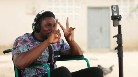 African Man in Wheelchair Using Smartphone for Video Call Stock Footage 346244748