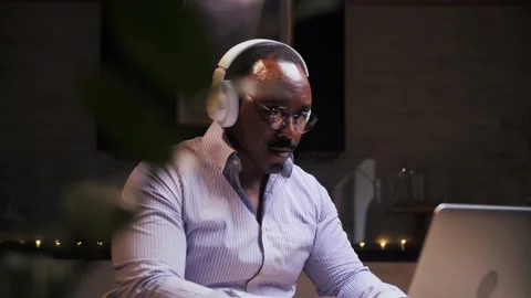 African man work remotely with headphones at home.Young business person with Stock Footage 209223944