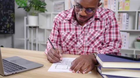 African man working from home using laptop and web camera, taking a note Stock-Footage 165438518