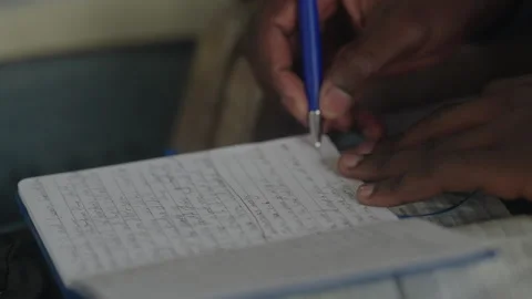 African Man Writing in Notebook Stock Footage 247679561