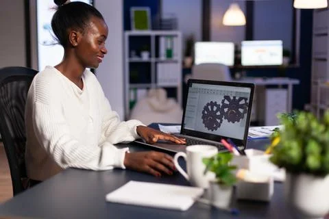 African mechanical designer working on computer late at night Stockfoto's