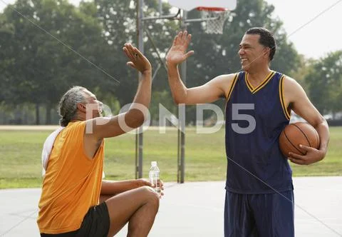 African men high-fiving on basketball court Stock Photos
