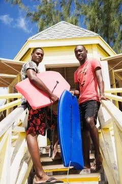 African men holding body boards Stock Photos