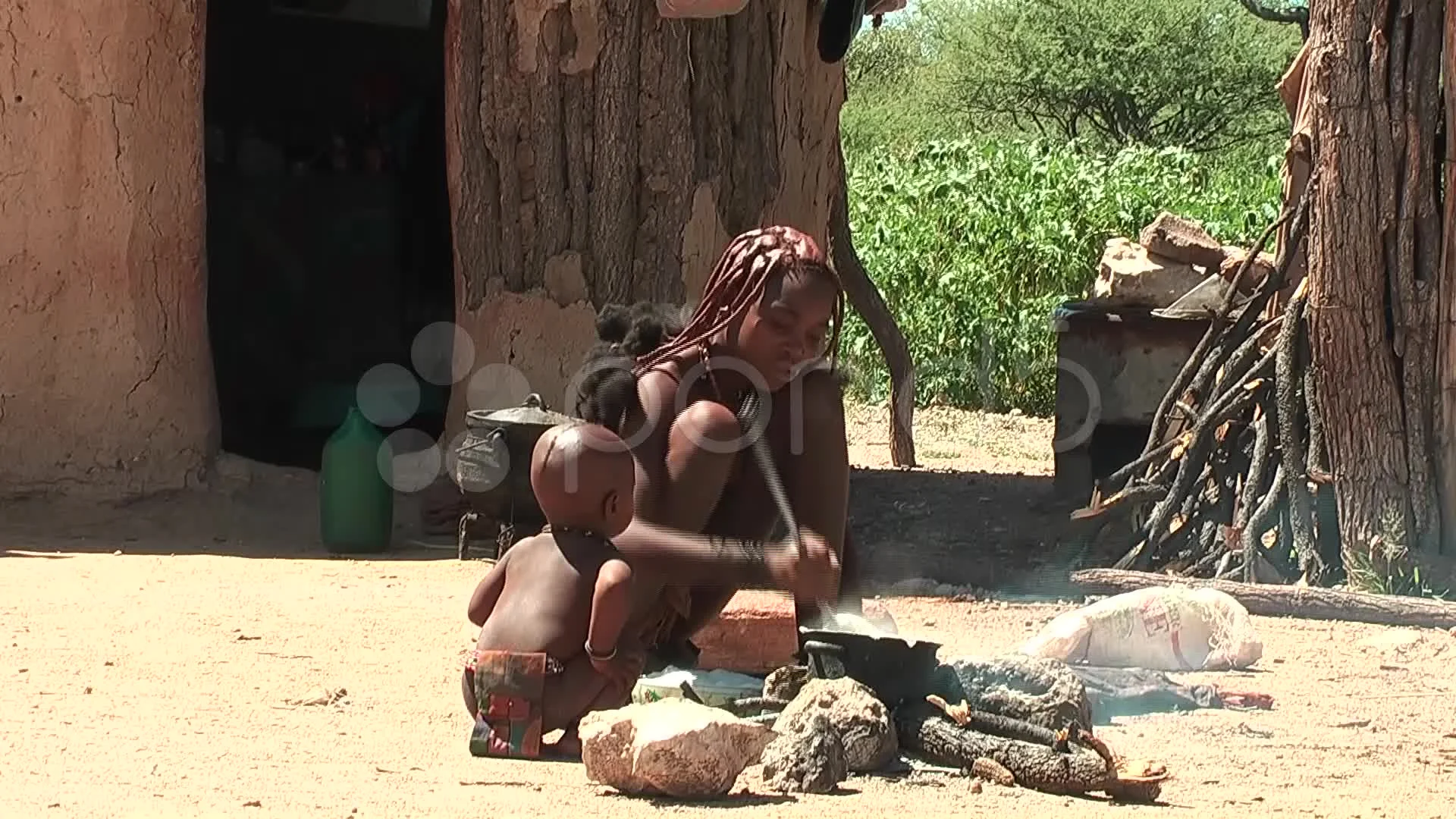 African native tribes - Young Himba girl cooking on fire in Namibia