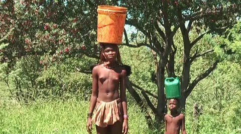 African native tribes - Young Himba girl carrying water bucket in Namibia Video stock 26915609