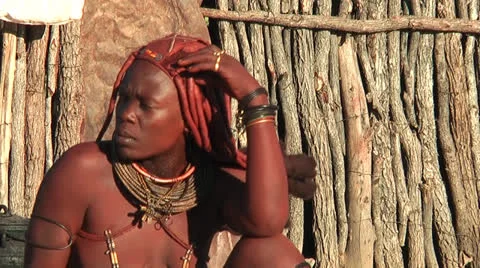 African native tribes - Young Himba woman observing others dancing and singing Stock-Footage 27029166