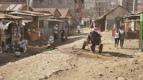 An African old man pulling a hand cart on a rocky road in Kenyan slums Stock Footage 109241082