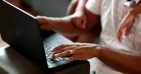 African parent using laptop computer with child son Stock Footage 143761705