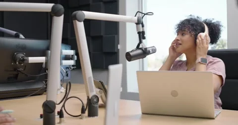 African podcast hosts in recording studio, woman leaning to mic initiating Stock-Footage 342642098