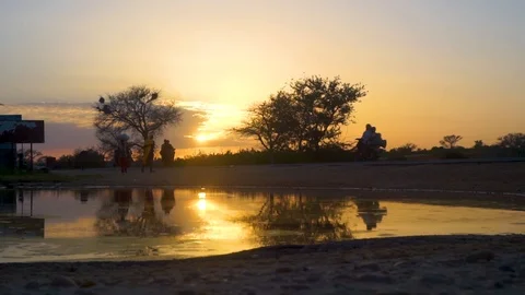 African road reflection with people at sunset Stock Footage 102411615