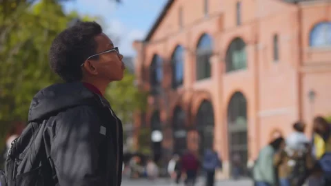 African schoolboy going to school standing outdoors and looking at brick Stock Footage 140597622