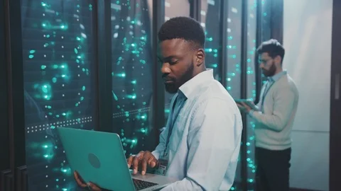 African smart IT engineer using modern notebook checking working system of Stock Footage 119232283