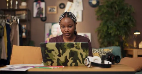 African software developer using computer in living room to code, debug, and Stock Footage 244759051