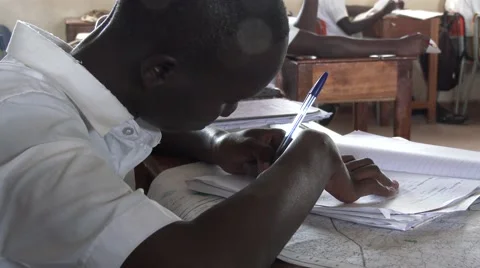 African student writing in notebook at school-homework handwriting - Edu Africa Stock Footage 58990372