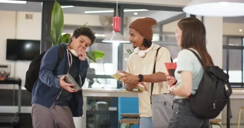 African students standing in campus lounge, left male angling tablet showing Stock Footage 344340493