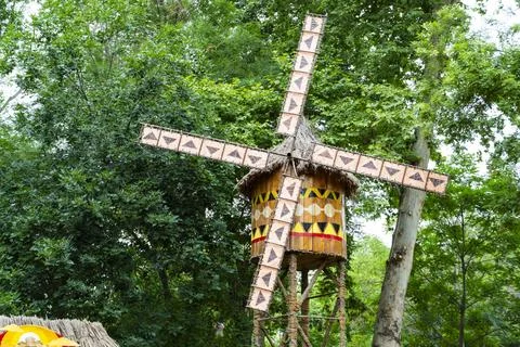 African Style Decorative Windmill in Theme Park Surrounded by Green Trees Stock Photos