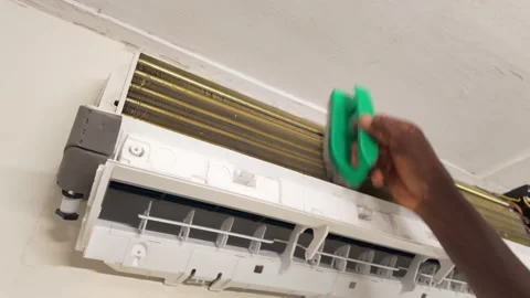 African Technician Cleaning Wall-Mounted Air Conditioner at Home 库存影片 346004675